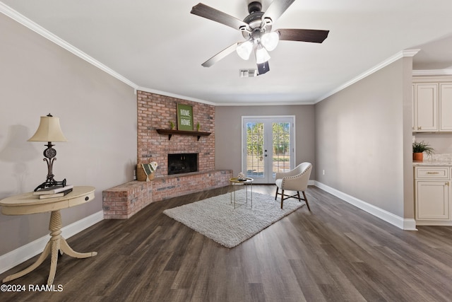 living room with a brick fireplace, ceiling fan, french doors, dark hardwood / wood-style floors, and ornamental molding