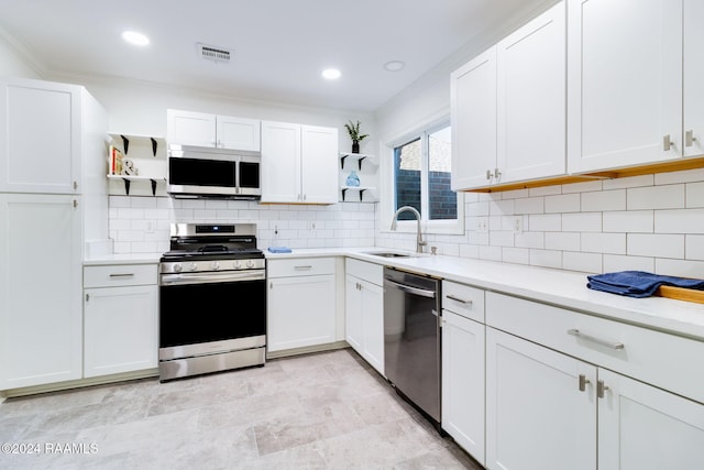 kitchen with appliances with stainless steel finishes, backsplash, white cabinetry, and sink