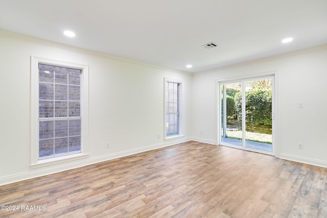 empty room featuring ornamental molding and light wood-type flooring