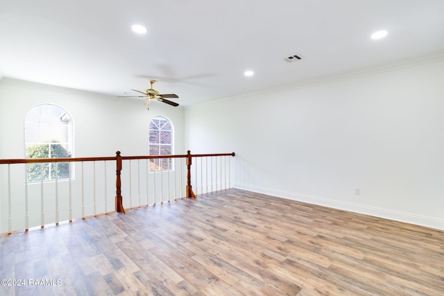 empty room with ceiling fan, light hardwood / wood-style floors, and ornamental molding