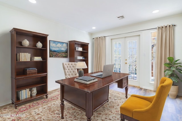 office area with light hardwood / wood-style floors, ornamental molding, and french doors