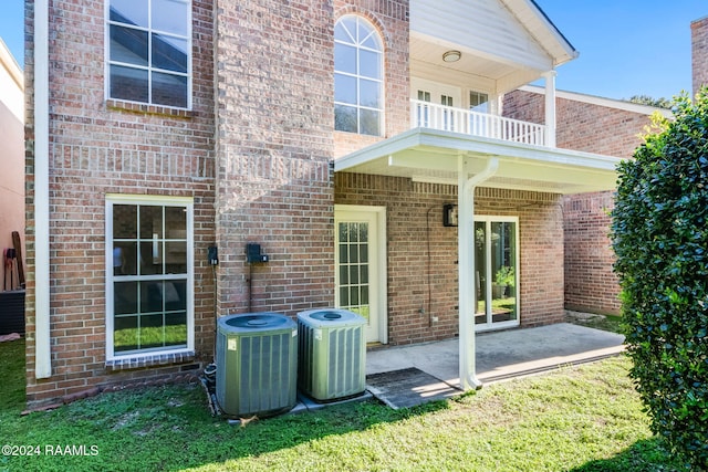 rear view of house with a balcony, central AC, and a patio area