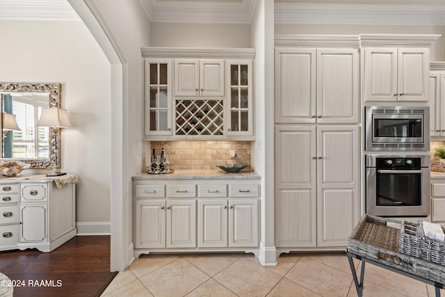 kitchen with ornamental molding, white cabinets, and stainless steel appliances