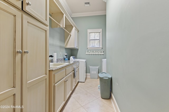 washroom with ornamental molding, sink, light tile patterned flooring, cabinets, and washer and dryer