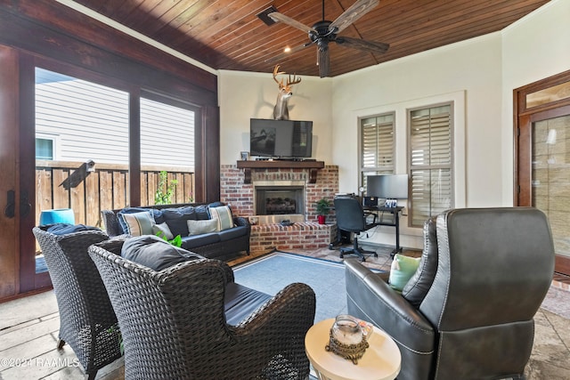 living room with ornamental molding, ceiling fan, a brick fireplace, and wooden ceiling