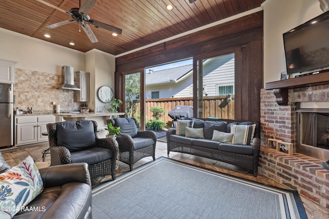 living room with ceiling fan, a fireplace, and wooden ceiling