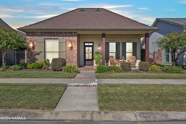 view of front of home with a yard and covered porch