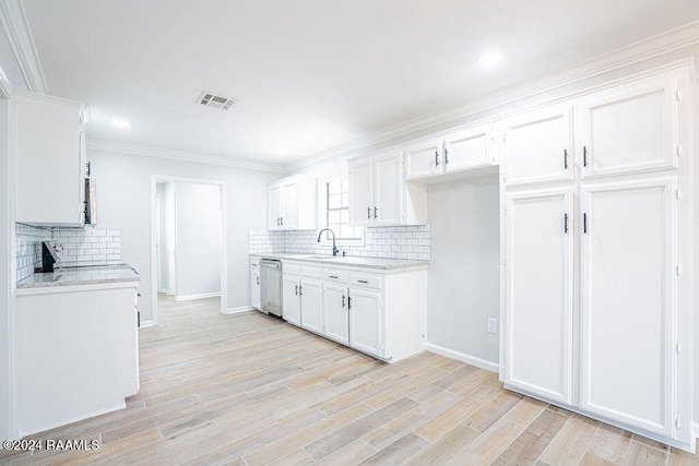 kitchen with light stone counters, dishwasher, white cabinets, sink, and light wood-type flooring