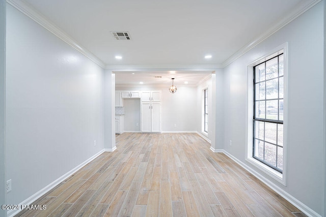 unfurnished room featuring a chandelier, light hardwood / wood-style flooring, and crown molding