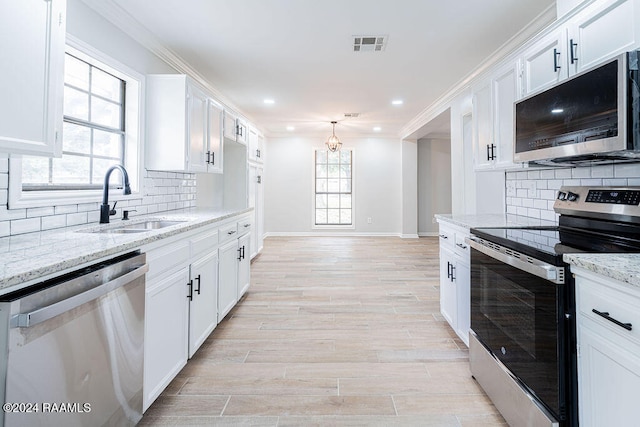 kitchen with tasteful backsplash, white cabinets, light stone counters, and stainless steel appliances