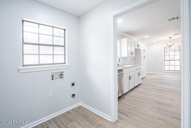 laundry room featuring hookup for an electric dryer, washer hookup, an inviting chandelier, sink, and light hardwood / wood-style floors