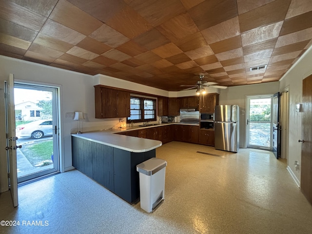 kitchen featuring ceiling fan, dark brown cabinets, sink, stainless steel appliances, and kitchen peninsula