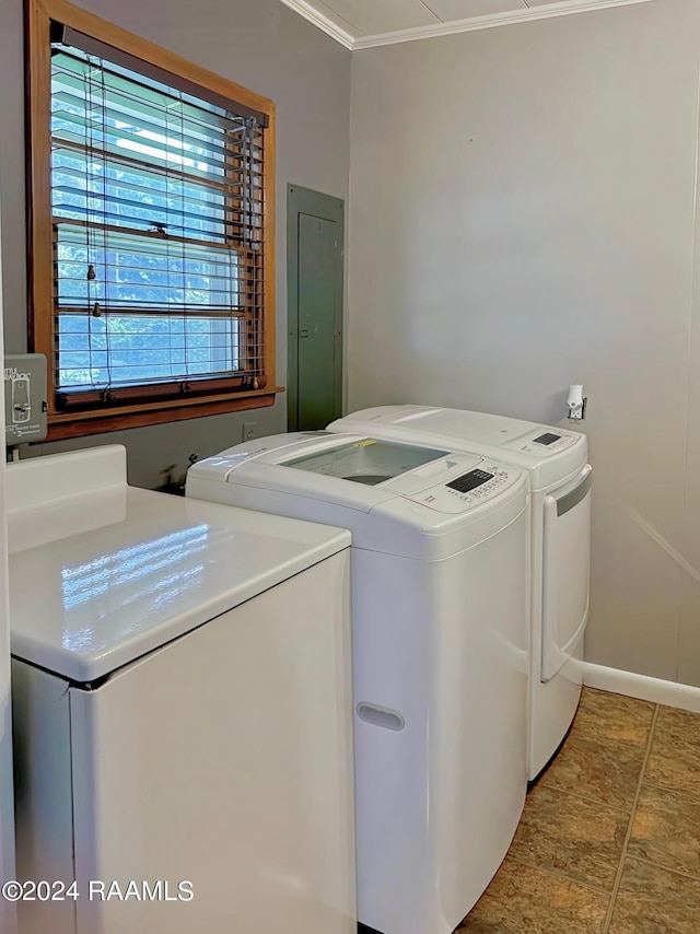 laundry room featuring electric panel, crown molding, and washer and clothes dryer