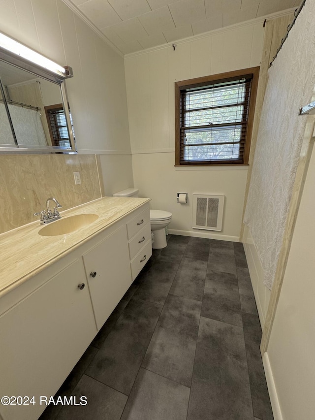 bathroom with vanity, ornamental molding, heating unit, backsplash, and toilet