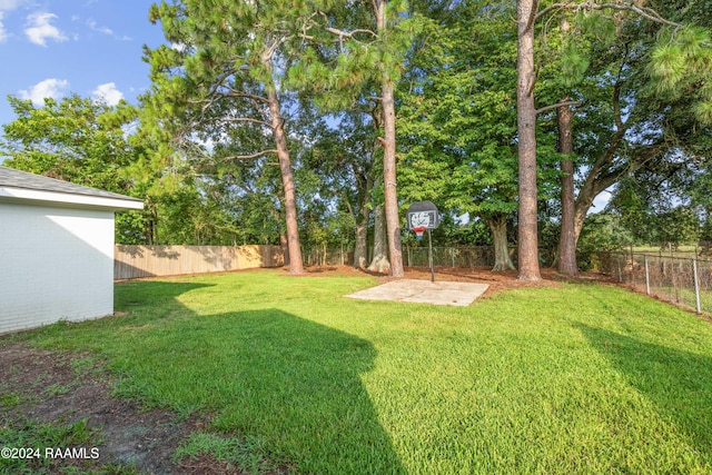 view of yard featuring basketball hoop