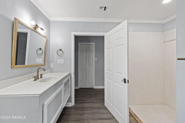 bathroom with wood-type flooring, vanity, and ornamental molding