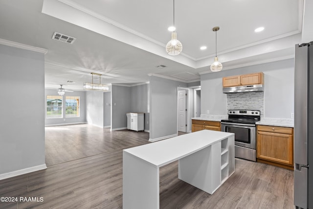 kitchen featuring a kitchen island, wood-type flooring, stainless steel appliances, tasteful backsplash, and ornamental molding