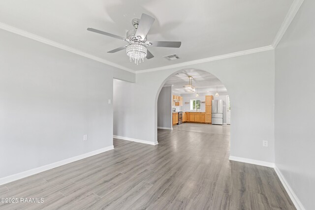406 Orange Grove Ave, New Iberia, LA 70560 - unfurnished living room with arched walkways, a ceiling fan, baseboards, ornamental molding, and wood finished floors