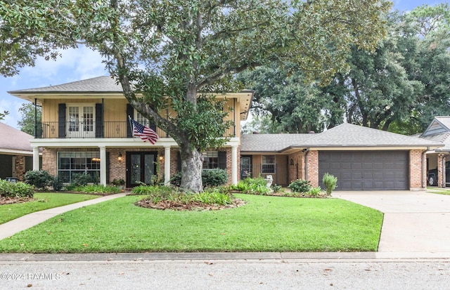 view of front facade with french doors, a front lawn, a garage, and a balcony