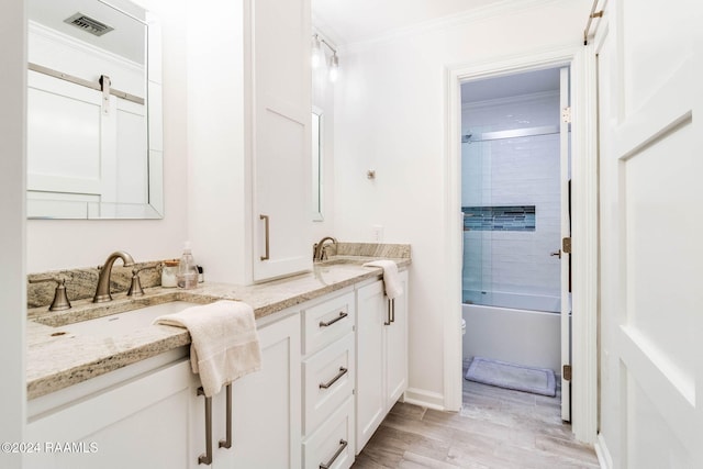 bathroom with tiled shower / bath combo, vanity, hardwood / wood-style floors, and ornamental molding