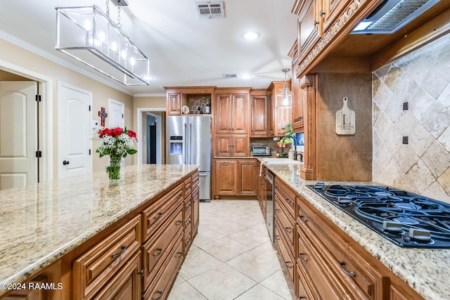 kitchen with pendant lighting, backsplash, light stone countertops, and stainless steel appliances