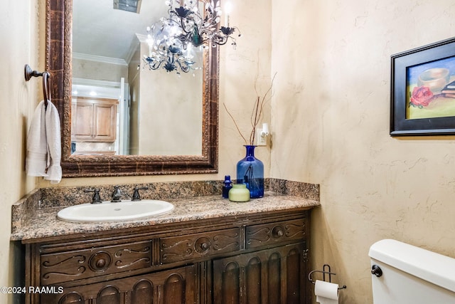 bathroom with ornamental molding, vanity, and toilet