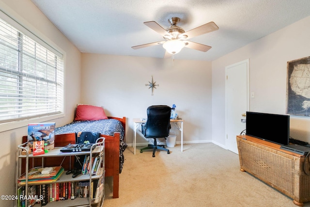 bedroom with a textured ceiling, light colored carpet, and ceiling fan