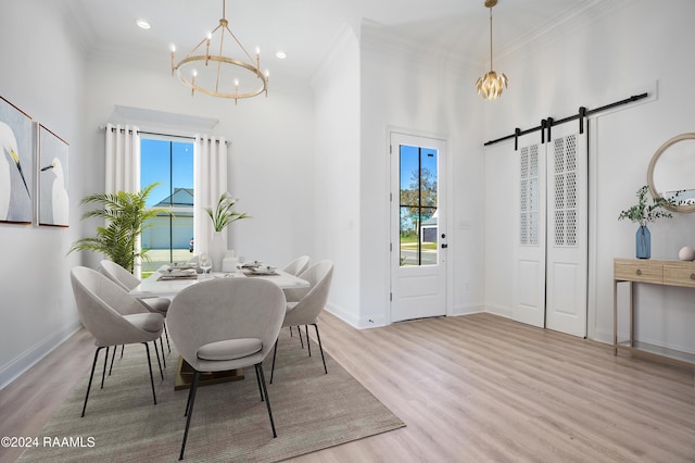 dining room with a water view, a wealth of natural light, a chandelier, and light hardwood / wood-style floors