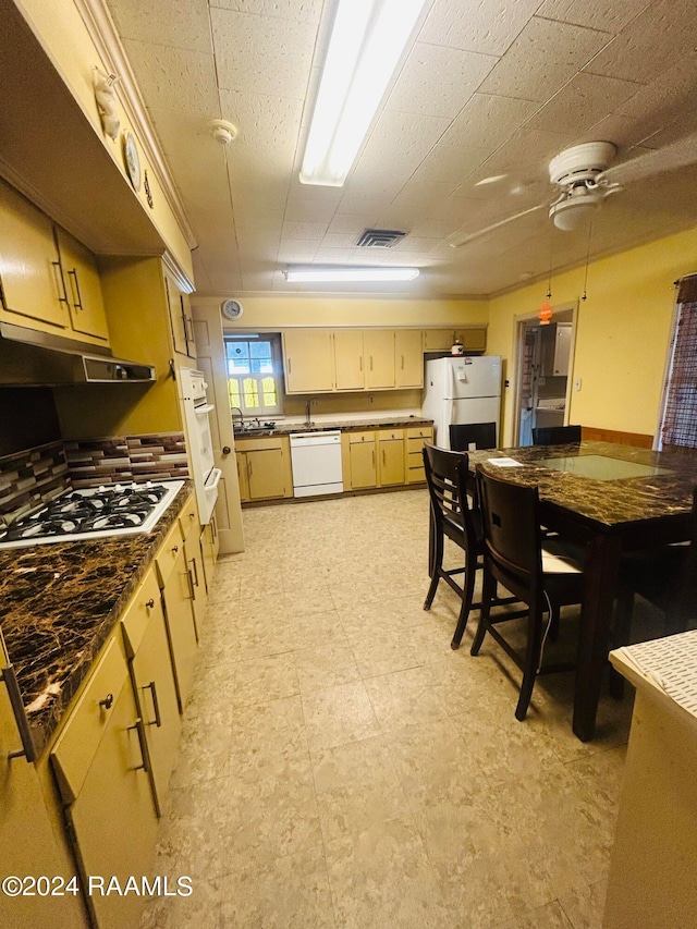 kitchen featuring ceiling fan, light brown cabinetry, hanging light fixtures, and white appliances