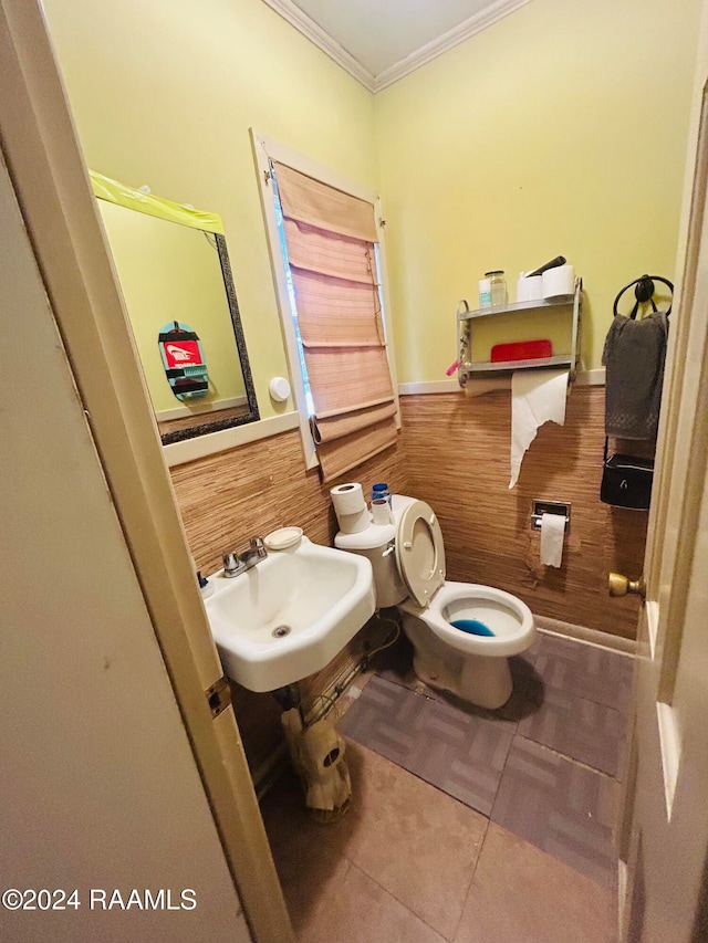 bathroom featuring tile patterned flooring, toilet, ornamental molding, and sink