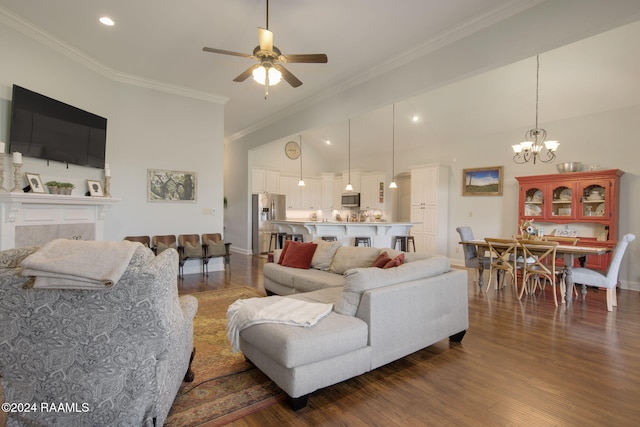 living room featuring ceiling fan with notable chandelier, a fireplace, ornamental molding, and dark wood-type flooring