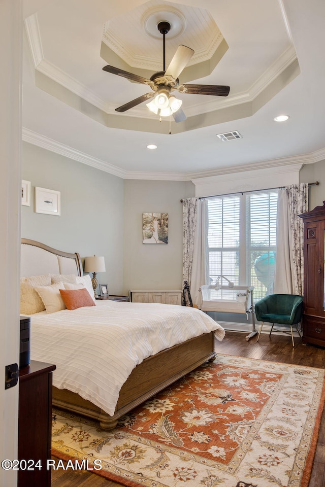 bedroom with a raised ceiling, crown molding, ceiling fan, and hardwood / wood-style flooring