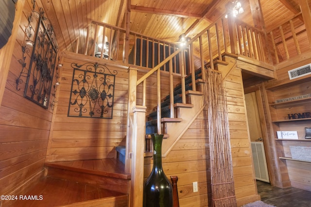 stairway featuring wooden ceiling and wood walls