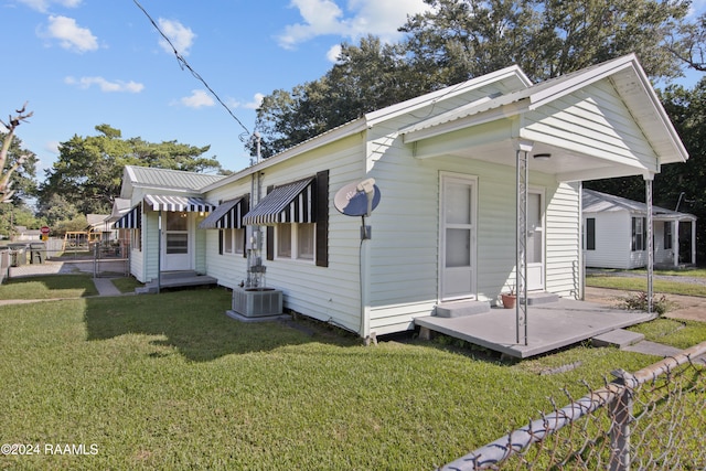 view of side of home featuring cooling unit and a lawn