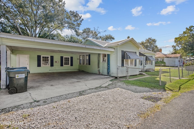 ranch-style home featuring a carport and a front yard