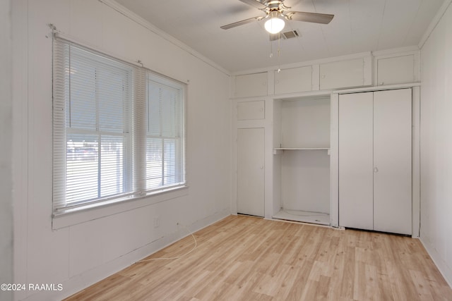 unfurnished bedroom with light hardwood / wood-style floors, ornamental molding, and ceiling fan