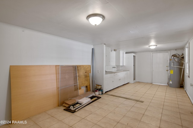 interior space featuring white cabinets, electric water heater, and light tile patterned floors