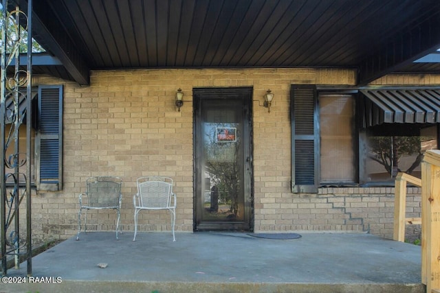 view of exterior entry with a patio area