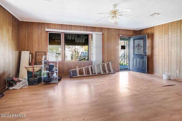 miscellaneous room featuring wood walls, light hardwood / wood-style floors, and ceiling fan