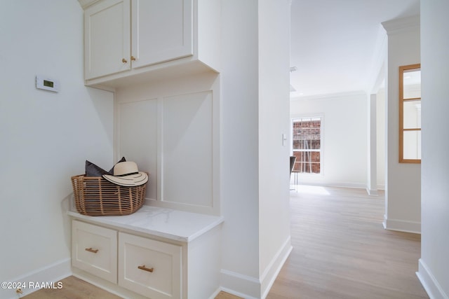 mudroom with ornamental molding and light wood-type flooring