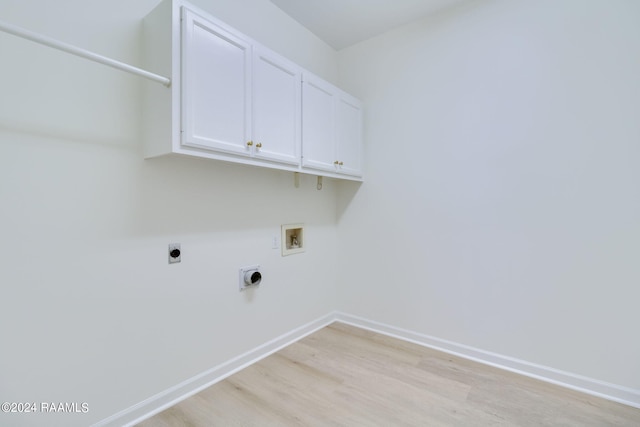 washroom with hookup for an electric dryer, hookup for a washing machine, light hardwood / wood-style floors, and cabinets