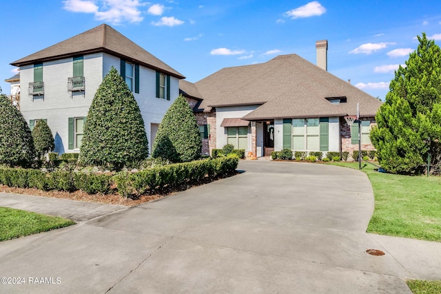 102 English Gardens Pkwy, Lafayette, LA 70503 - view of front of house featuring concrete driveway, a chimney, a front yard, and brick siding