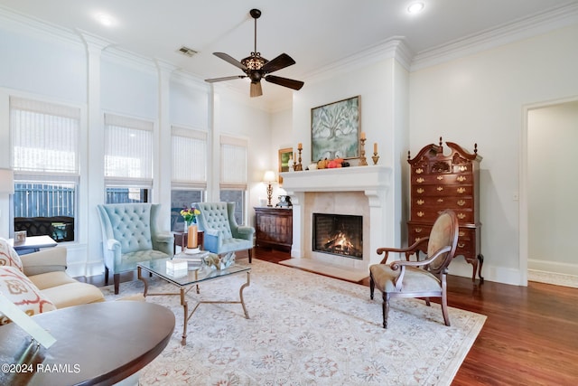 102 English Gardens Pkwy, Lafayette, LA 70503 - living room featuring a warm lit fireplace, crown molding, a ceiling fan, visible vents, and wood finished floors