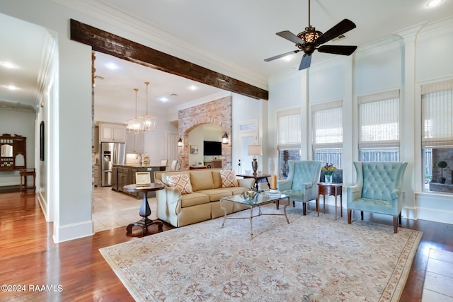 102 English Gardens Pkwy, Lafayette, LA 70503 - living room with beam ceiling, light wood finished floors, ornamental molding, and ceiling fan with notable chandelier