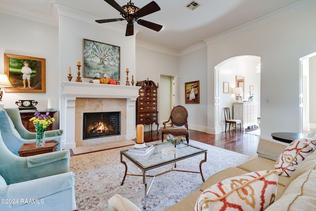 living room with a fireplace, ornamental molding, hardwood / wood-style floors, and ceiling fan