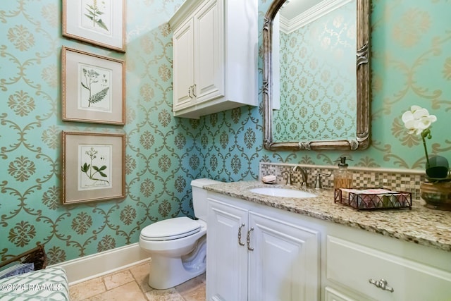 bathroom with ornamental molding, vanity, and toilet