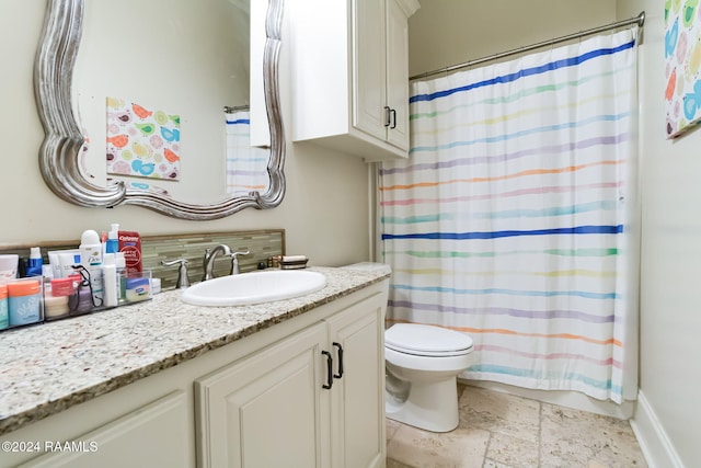 bathroom with curtained shower, vanity, and toilet