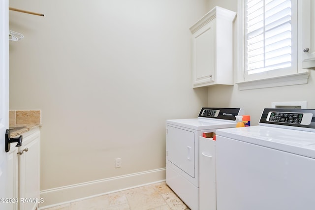 washroom featuring cabinets and washing machine and clothes dryer