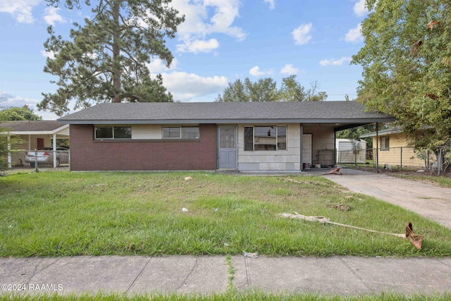 ranch-style house featuring a front lawn and a carport