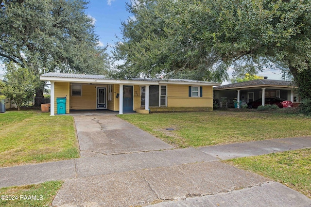 ranch-style home with a carport, a front yard, and central AC unit